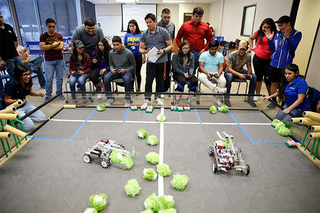 The IDEA high school students seen here are guiding robots they built to collect objects representing crops. The occasion was a smart farm competition, during the UTRGV Texas Manufacturing Assistance Center Summer Camp, held at the UTRGV Teaching Site in McAllen. (UTRGV Photo by Paul Chouy)