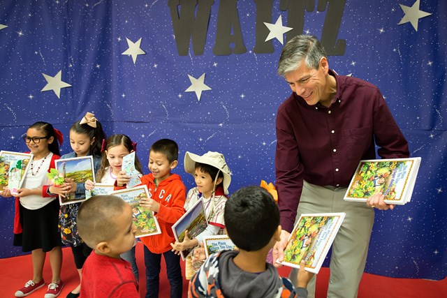 Children's book author James Luna hands out his book to students during a Texas Book Festival Reading Rock Stars event during UTRGV’s FESTIBA.