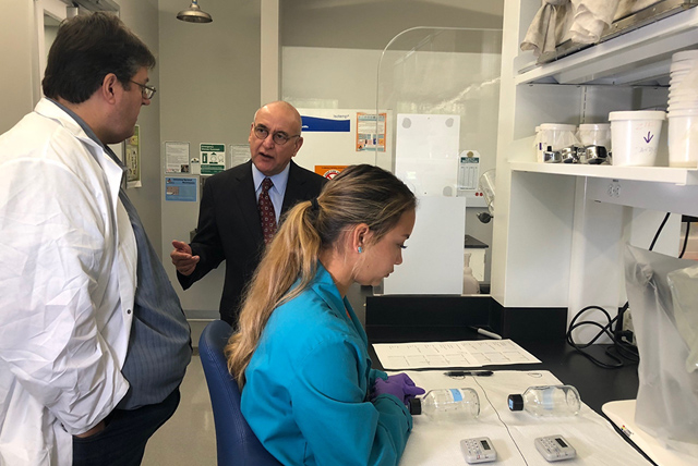 Dr. Christopher Vitek (at left), UTRGV associate professor of biology, and state Rep. R. D. “Bobby” Guerra (center), spoke this week in the Zika research lab on the Edinburg Campus, as biology graduate student and lab manager Heather Hernandez performed tests on pesticide effectiveness. Guerra and other guests toured the facility and got updates on important research UTRGV is conducting on Zika and other vector-borne diseases. (UTRGV Photo by Victoria Brito)