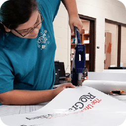 Printing Services employee working on signage material