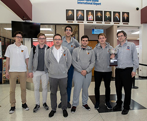 The UTRGV Vaqueros Chess Team returned to the Rio Grande Valley just after 12 a.m. Monday from New York City, riding its second consecutive national win over rival Webster University in the Final Four of Collegiate Chess. The team is seen here just after arrival at the Brownsville South Padre Island International Airport. Coach Bartek Macieja, far right, proudly displays the President’s Cup trophy. (UTRGV Photo by David Pike)