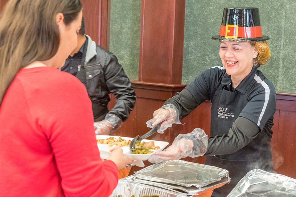 UTRGV employee serves Thanksgiving lunch to female student.
