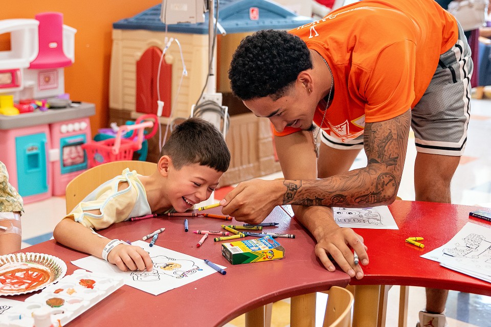 child and basketball player interact in classroom setting