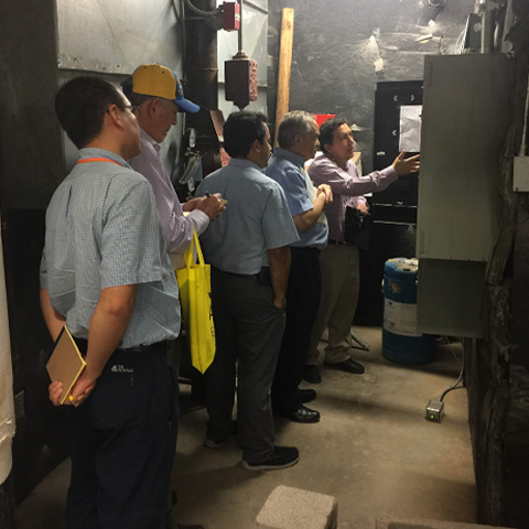 photo of men looking at a metal box for the demand response feasible study hosted by UTRGV