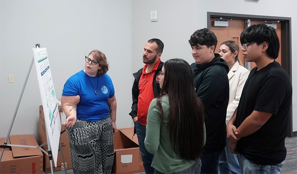 Kristen Hallas, a second-year Ph.D. student at UTRGV, presents her research poster to La Joya ISD students during a recent event celebrating the legacy of Florence Nightingale in Edinburg. (UTRGV Photo by Jesus Alferez)