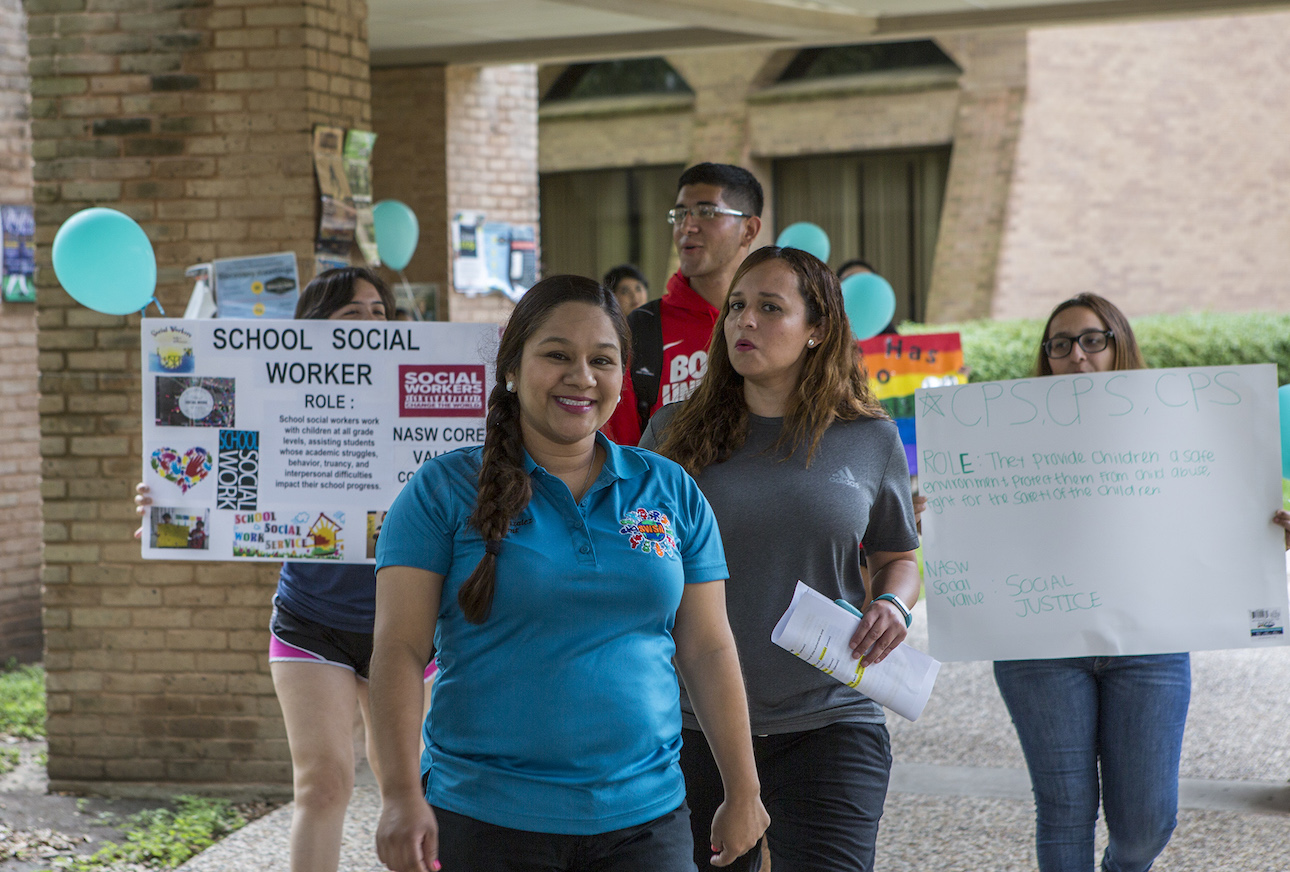 Students walking with informative signs about social work