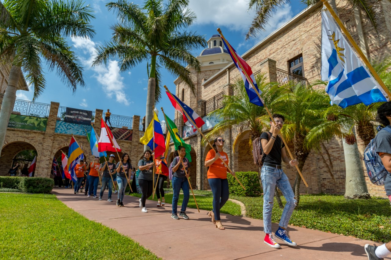 Students walking holding country flags