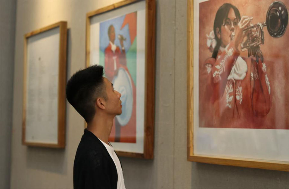 Student looking at painting in a gallyery exhibit