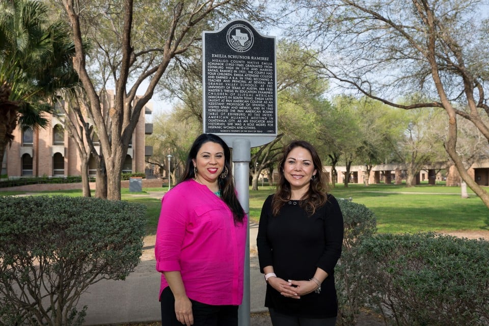 Two teachers standing by post marking historical landmark