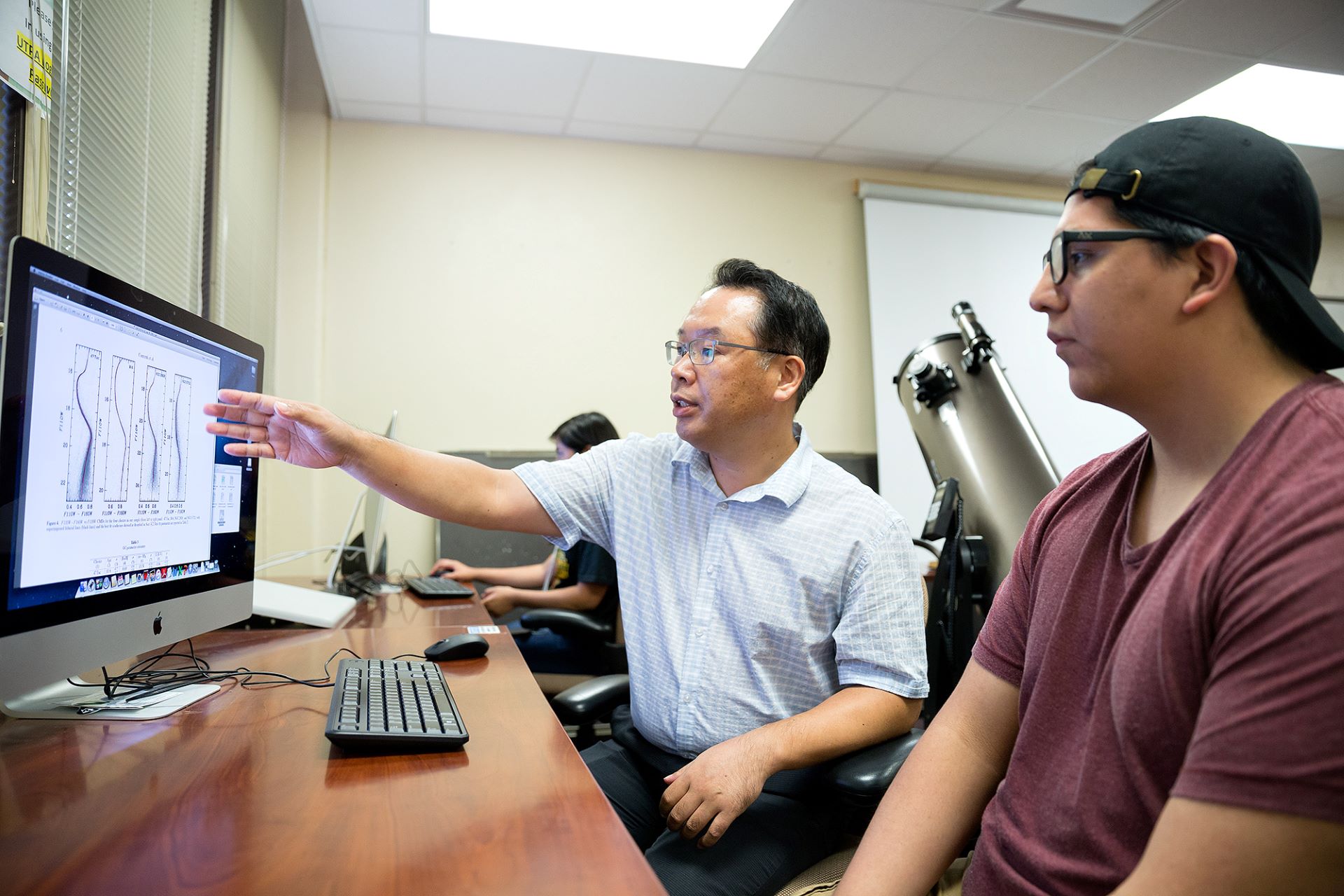 Professor showing computer screen to student