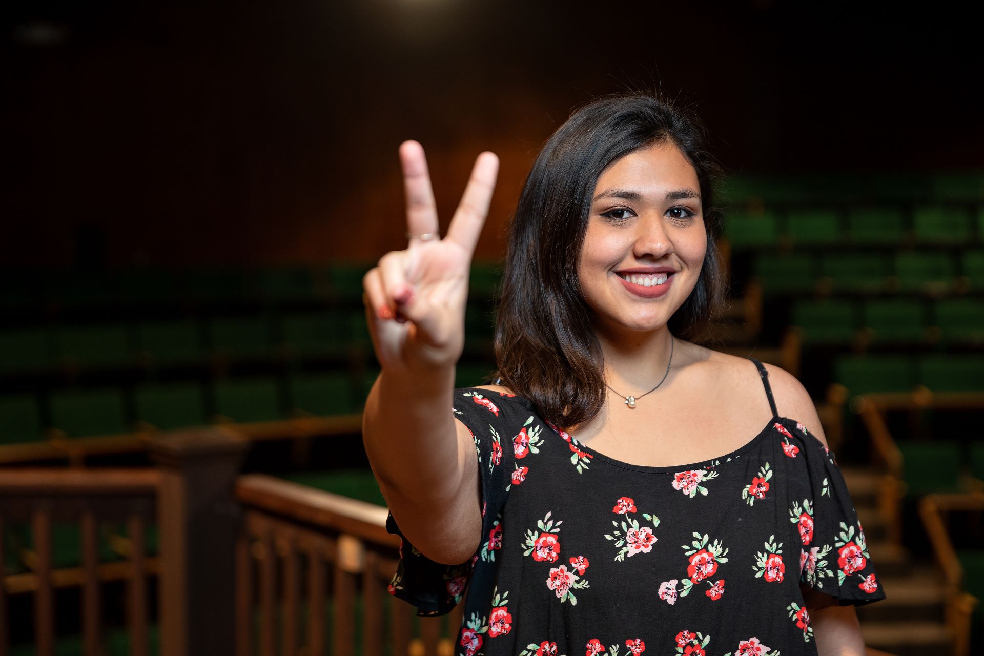 Female student holding a V's Up hand sign 