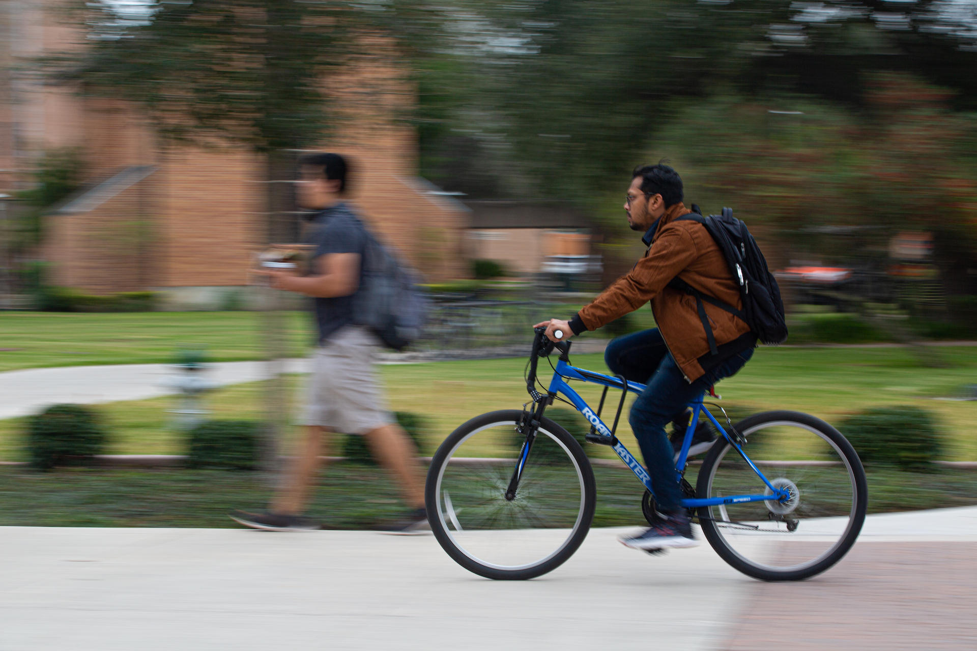 student riding bike through campus