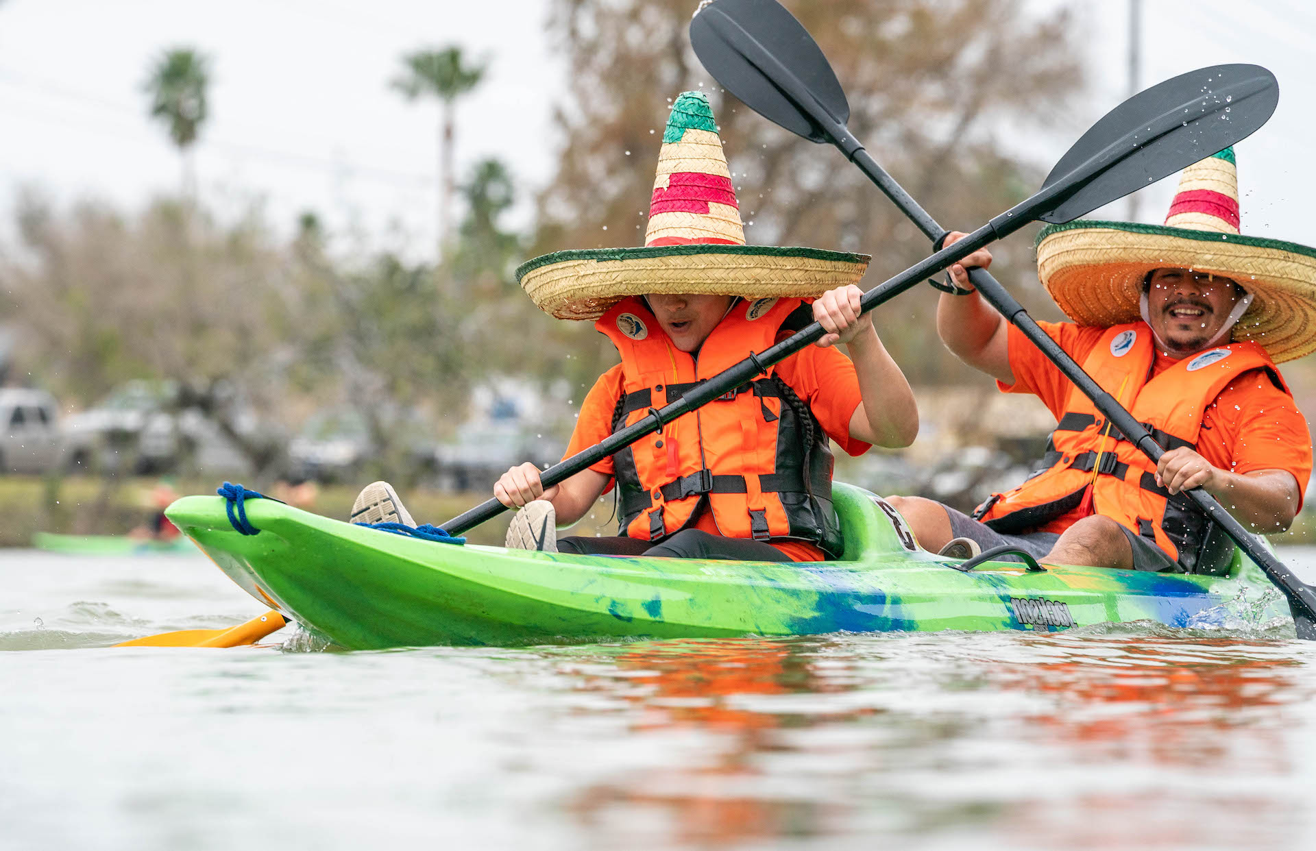 anthropology students using oars to move kayak through water