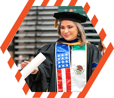 graduate in regalia with American flag and Mexican flag stole