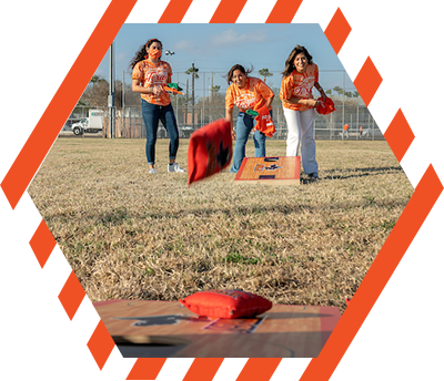 women play bean bag toss