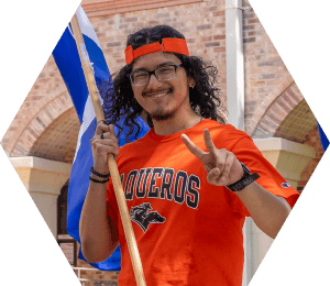 Vaquero male student holding International flag