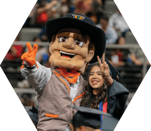 vaquero mascot at graduation posing with student