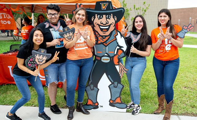 Student pose with Victor Vaquero graphic