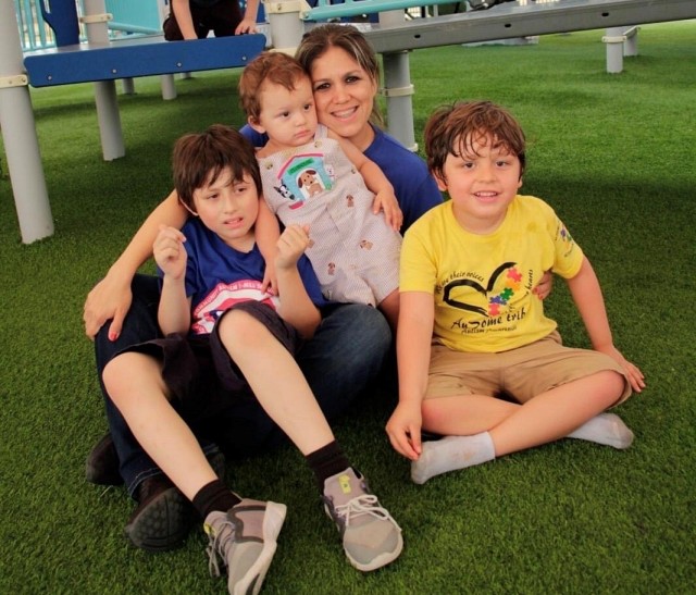 Susana Perez and her three children laying on the playground