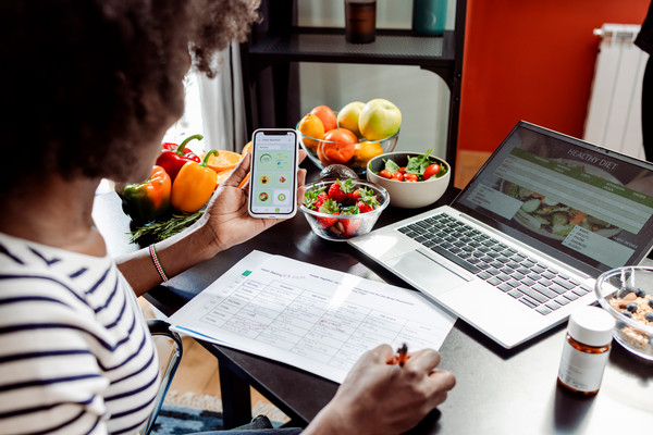 young woman looking at laptop creating a meal plan 