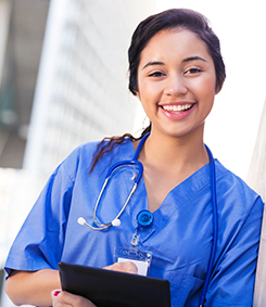 Nurse smiles wearing a white lab coat and a stethoscope around her neck
