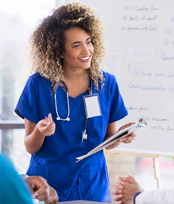 Clinical laboratory scientist smiling while holding a tablet