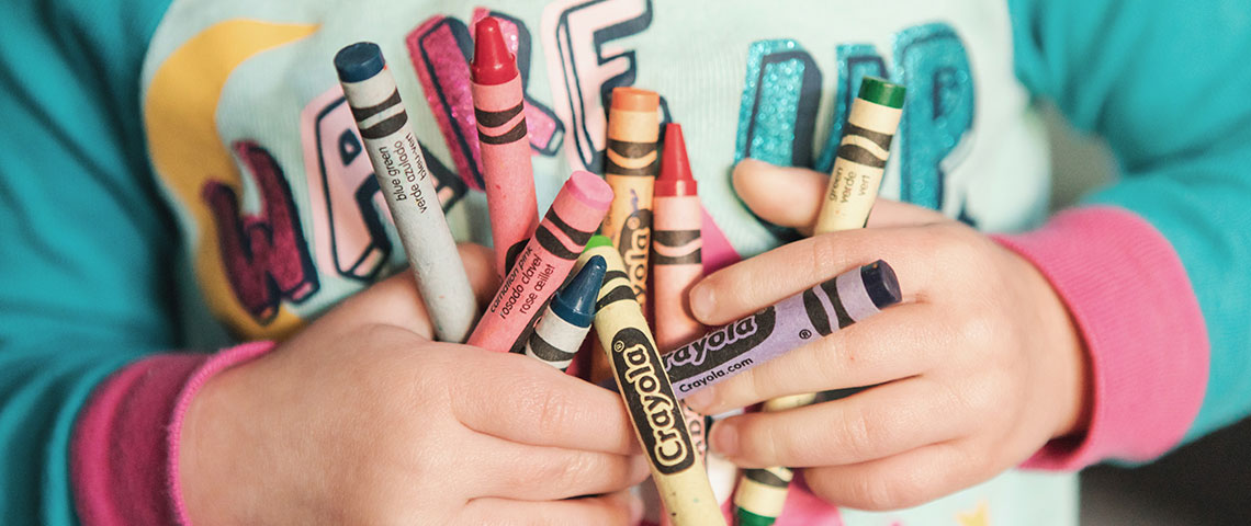 child holding crayons with both hands Banner