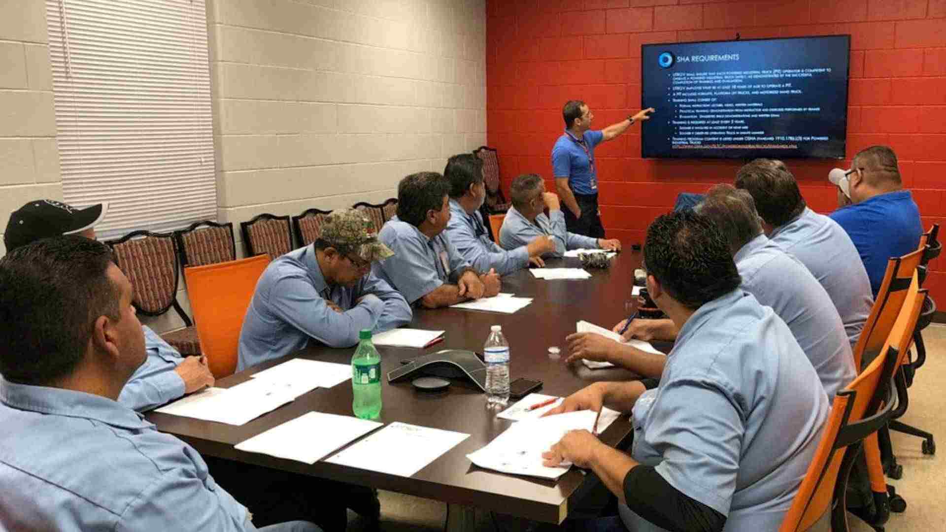 blue shirt university workers in a conference room having a training meeting