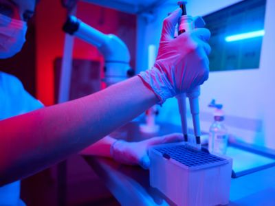person filling test tubes with electronic pipette