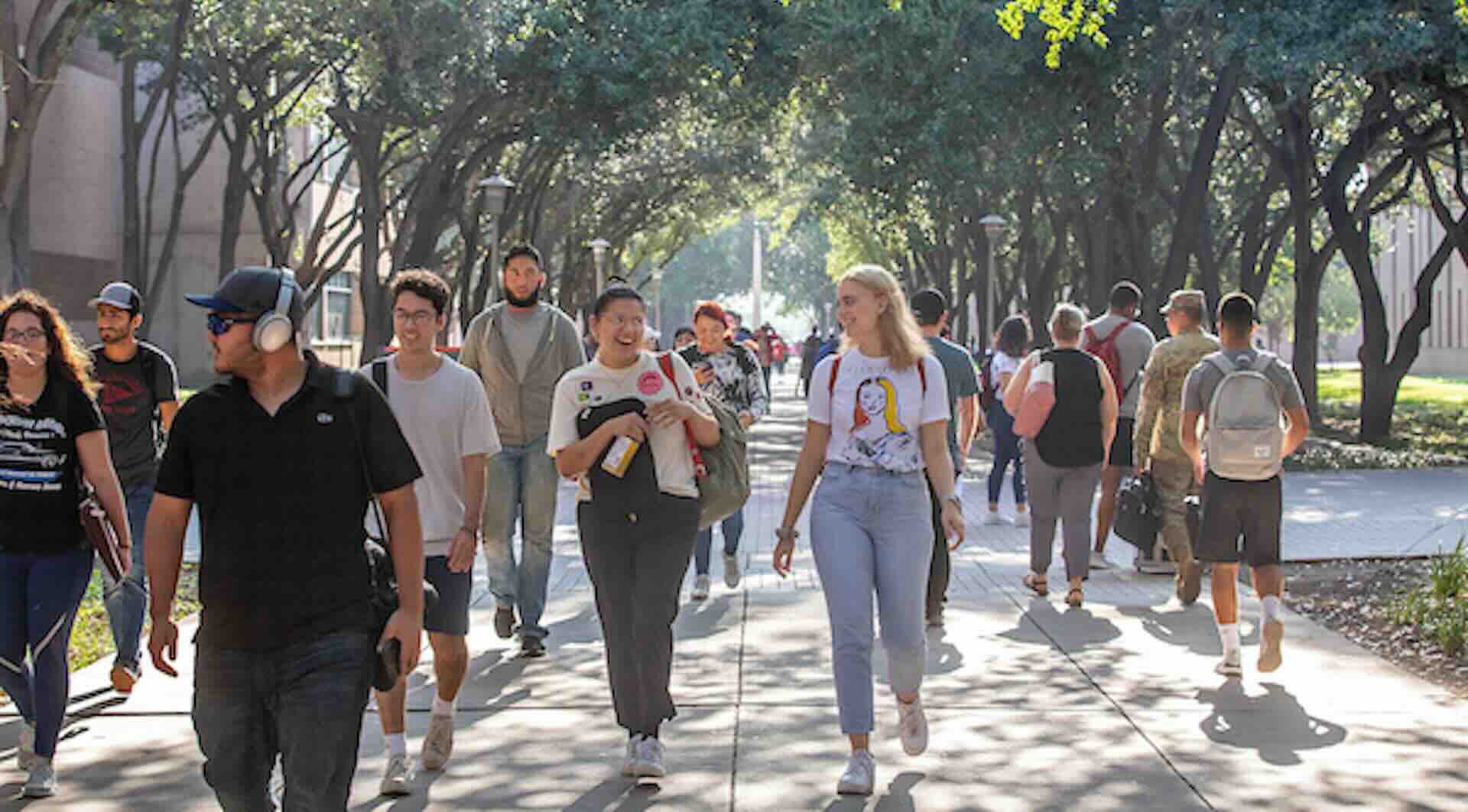 students walking under tree canopy at utrgv near the science building