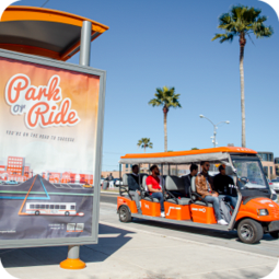 UTRGV students riding an orange VOLT cart