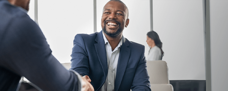 Business man smiling and giving a handshake to a potential partner