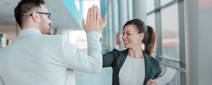 Business woman giving a high-five to a colleague for solving a conflict