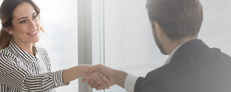 Business woman smiling and handshaking with a potential business partner