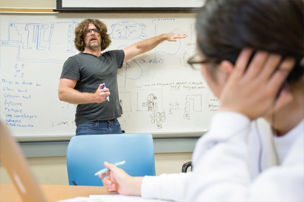 Instructor teaching students using a whiteboard.