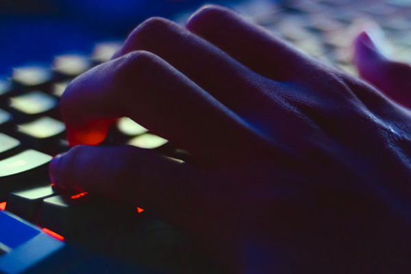 Close up photo of a hand typing on a keyboard