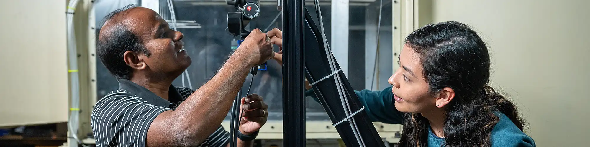 Professor works with a student to setup equipment.