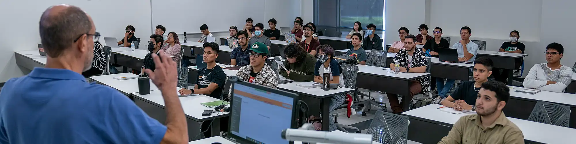 Photo of a class in session with students sitting at desks.