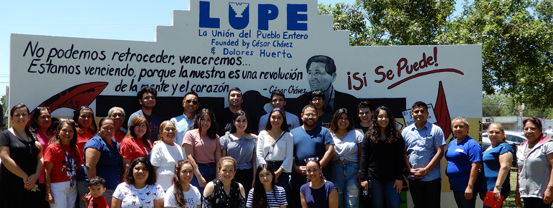 group photo of LUPE in front of their mural