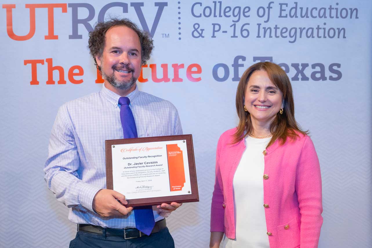 Dr. Javier Cavazos receiving the Outstanding Faculty Research Award from Dr. Alma D. Rodriguez