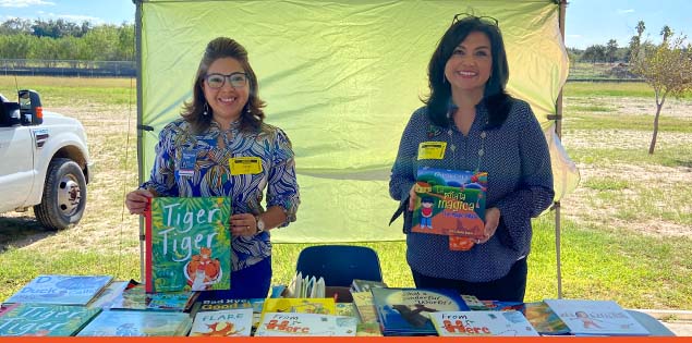 Two teachers showcasing children's books.