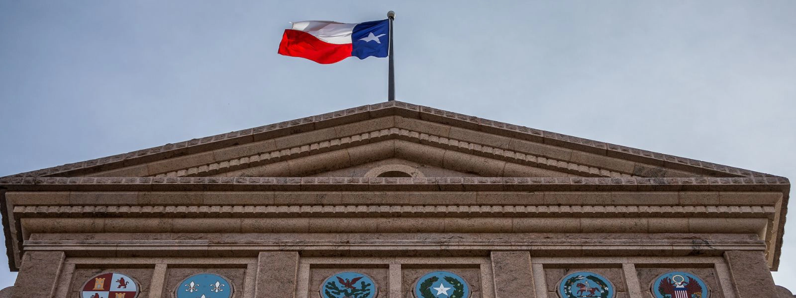 Texas flag over state capitol 