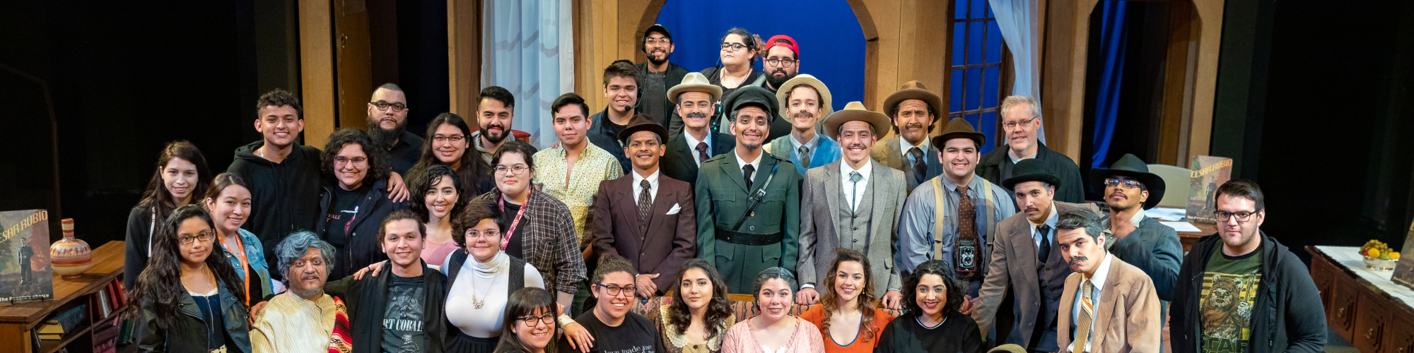 Entire cast of play posing for photo onstage.