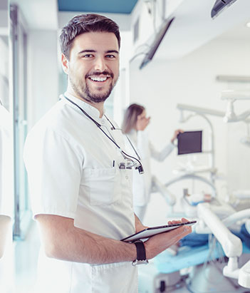 Nurse smiling at camera while holding notepad.