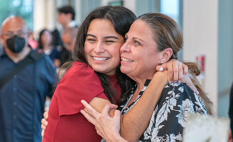 Student and parent hugging.