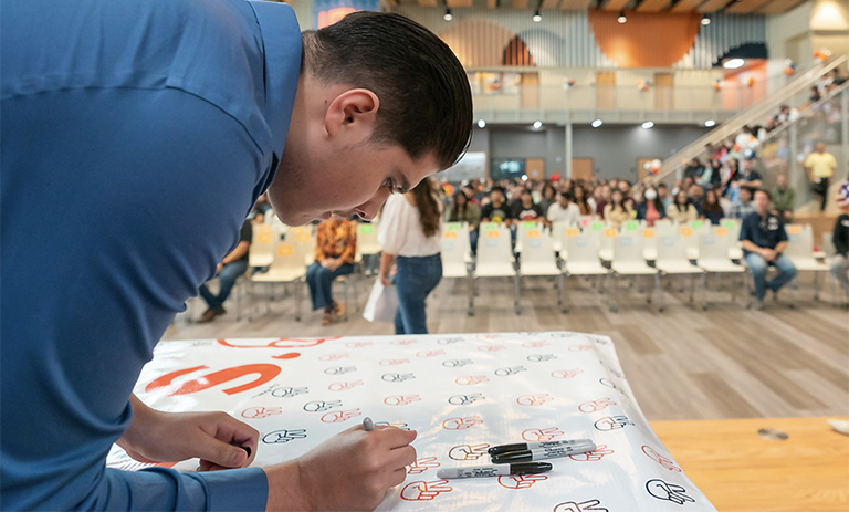 Student signing document.