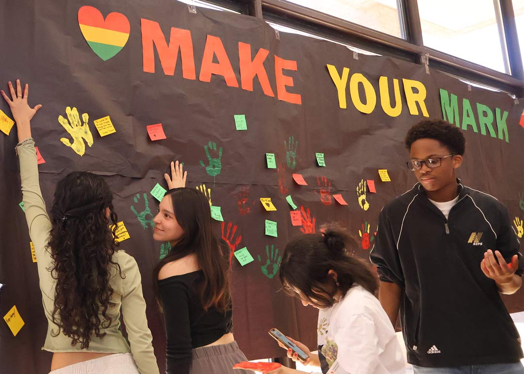 Students stamping their hand on a banner