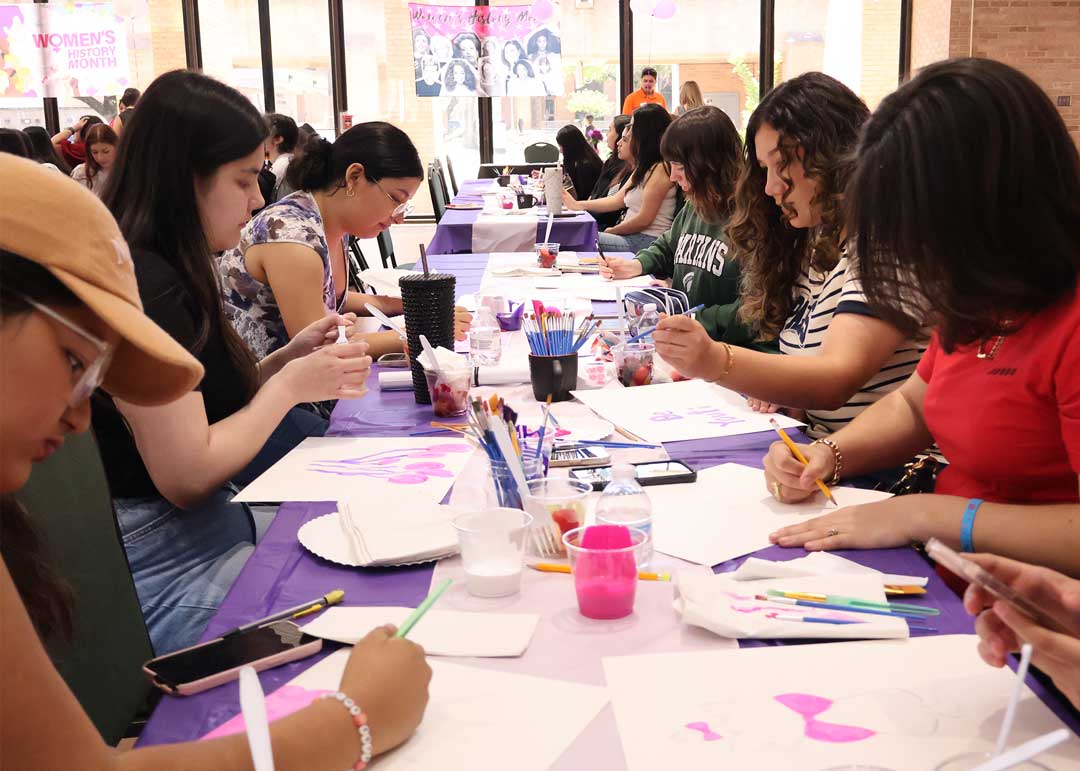 Students painting during Women's History Month event