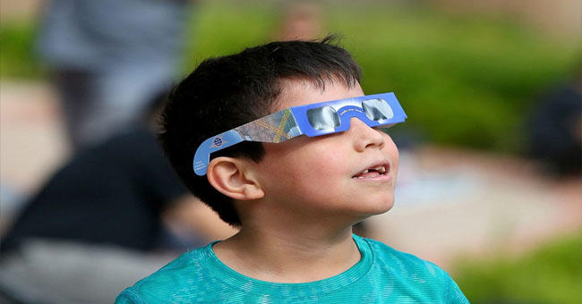 Child viewing solar eclipse safely