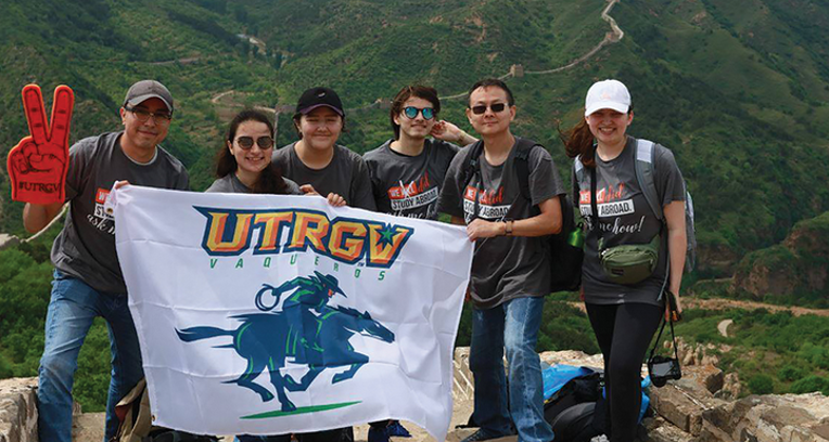 UTRGV International Students holding a UTRGV Vaqueros flag